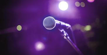 Picture of a microphone on a purple lighted background