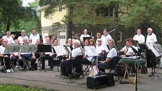 Picture of the members of Cortland Community Band smiling with their instruments
