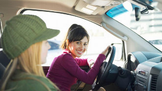 Two women in a car smiling