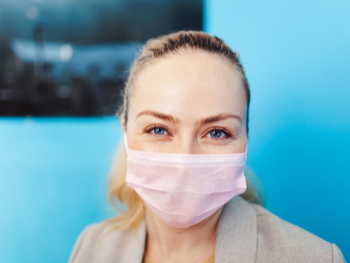 Woman wearing a mask, blue background