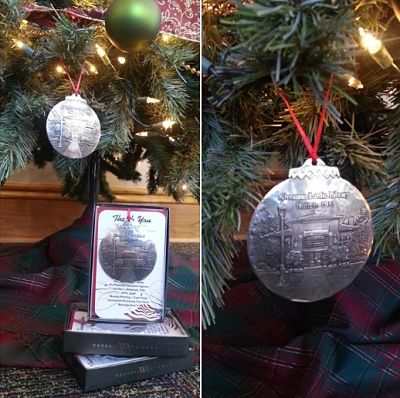 Picture of a silver Christmas ornament featuring an engraved image of the Library hanging on a tree