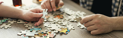 Picture of 3 hands working on a puzzle